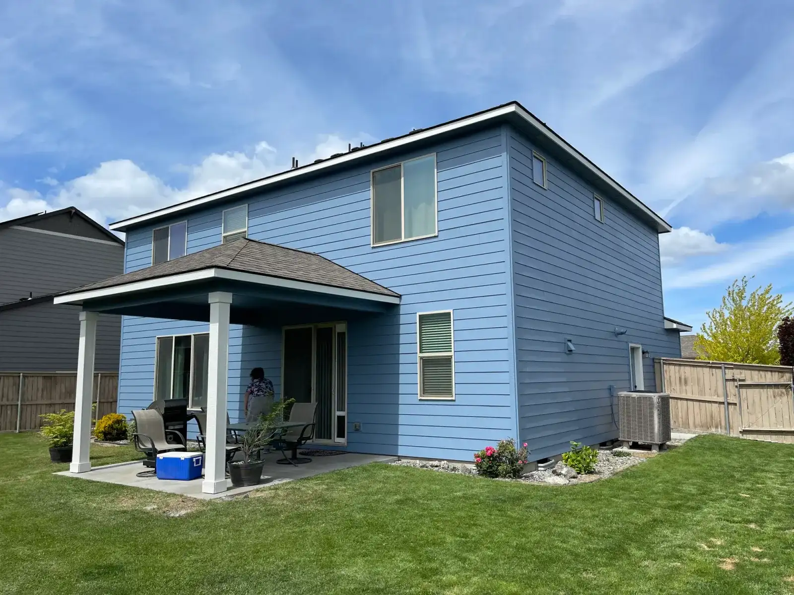 After: the back of the same home painted blue with white trim