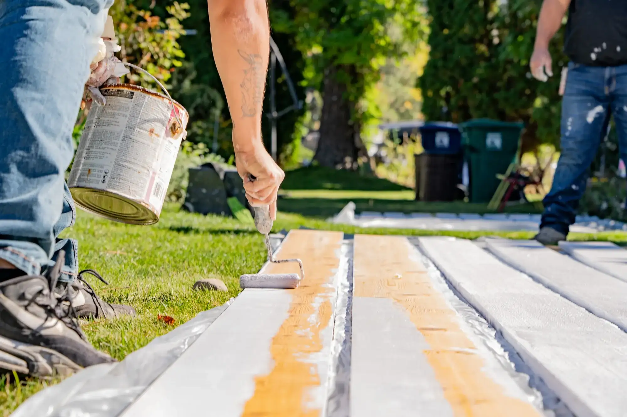 Rolling primer onto new fascia boards laid out in the yard before they go up