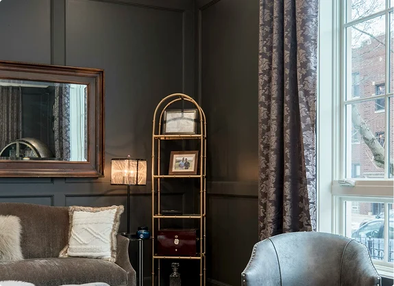 Stylish living room with dark painted walls, sofa, and decorative shelving